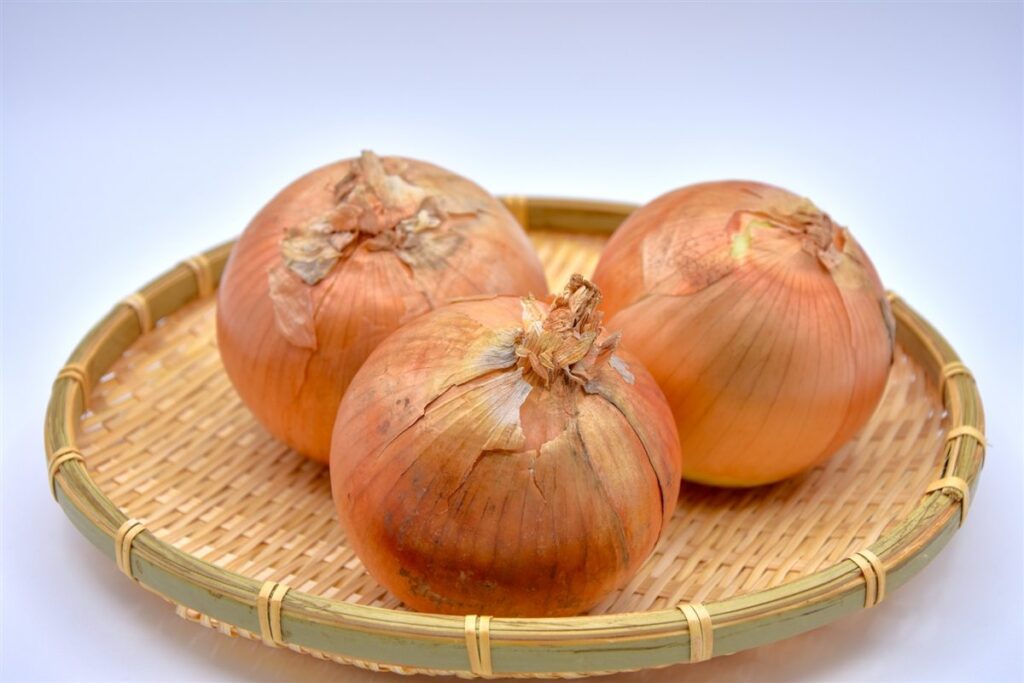 ざるにのせた玉ねぎ3個
